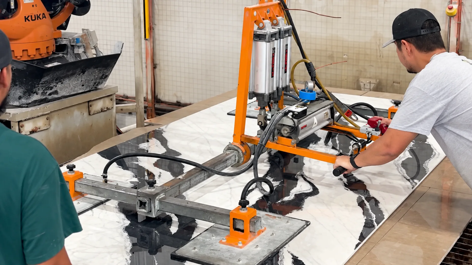 Toor team member guiding fabrication equipment across a veined stone slab